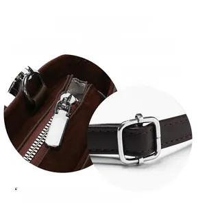 Detail of glossy silver metal hardware on a brown matte texture crossbody shoulder bag