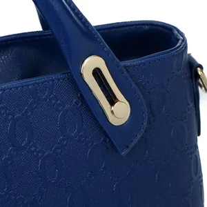 Bolso azul marino con textura circular en relieve y detalles metálicos dorados
