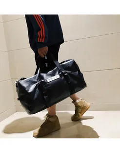 Détail d'un sac de sport en cuir PU noir avec anneaux métalliques et étiquette de marque