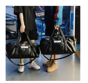 Détail d'un grand sac de voyage noir en cuir PU avec bandoulière et étiquette logo