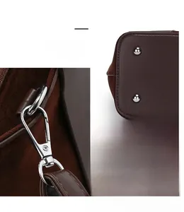 Detail of vintage brown bag showing silver metal hooks, stitching, and bottom rivets