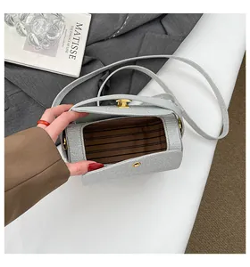 Gros plan d'un sac cylindrique argenté pailleté avec doublure marron et fermoir doré