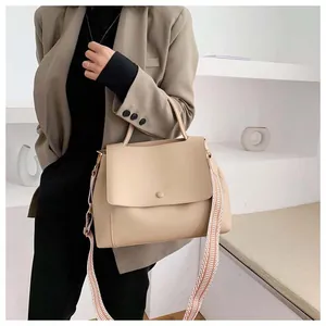 Detail of minimalist beige tote bag with a textured geometric woven wide shoulder strap