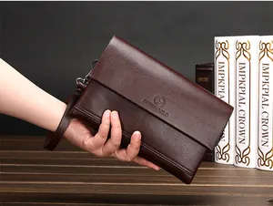 Detail van donkerbruine leren business clutch met kiezelnerf en logo-reliëfopdruk