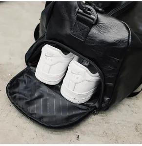 Détail du compartiment à chaussures dédié dans un sac de sport en cuir PU noir grainé
