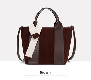 Detail view of brown tote bag with suede textures and striped fabric handle accent