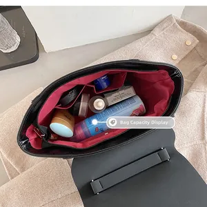 Detail view of the black leather bag interior with red lining and spacious storage