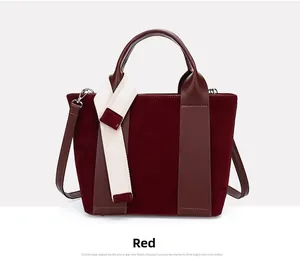 Detail of red paneled tote with matte suede texture and decorative woven ribbon