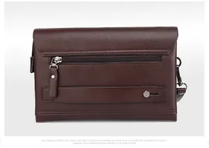 Gedetailleerde weergave van donkerbruine leren clutch met handgreep en ritssluiting