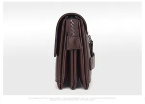 Detail van donkerbruine lederen clutch met fijne lycheekorrel en accordeon-structuur