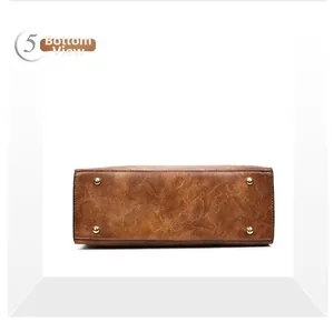 Vue détaillée du fond du sac seau en cuir marron avec quatre pieds de protection dorés