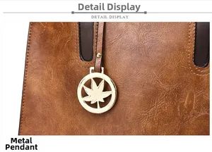 Vue macro d'un sac à main en cuir marron grainé avec pendentif feuille dorée