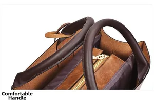 Détail des doubles anses confortables et du zip doré sur un sac seau en cuir marron