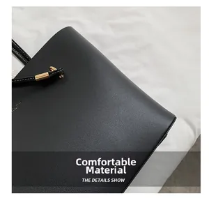 Detail shot of black leather tote bag showing comfortable fabric and gold metal buckles