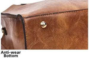 Détail du fond de sac en cuir marron avec rivets de protection dorés métalliques