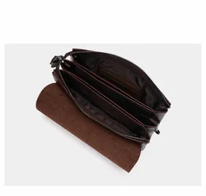 Binnenzicht van donkerbruine lederen clutch met meerdere vakken en kaartsleuven