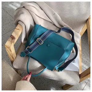 Peacock green bag detail featuring magnetic flap and wide geometric patterned strap