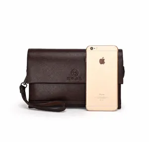Bruine lederen herenclutch naast een smartphone om de grote capaciteit te demonstreren
