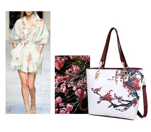 Dettaglio della borsa tote bianca con stampa di fiori di prugno rossi e finiture dorate