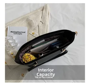 Top view of large black tote bag showing spacious internal capacity with books and tablet