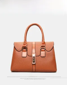 Front view detail of brown tote bag featuring textured lattice pattern and gold hardware