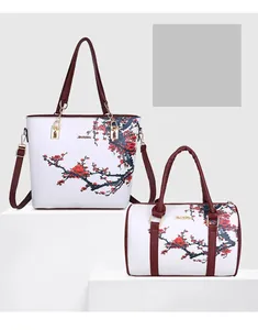 Dettaglio del set borse bianche con stampe floreali rosse e finiture in rosso bordeaux