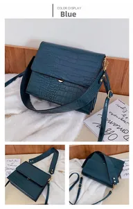 Detailansicht der blauen Handtasche mit Krokodilmuster, Goldbeschlägen und breitem Gurt