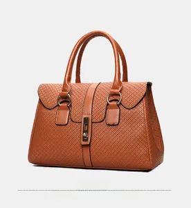 Detail view of caramel brown handbag with geometric embossing and gold clasp at 45 degrees