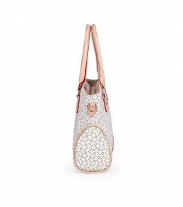 Vista lateral de bolso tote crema con estampados de estribos y detalles de anillas metálicas