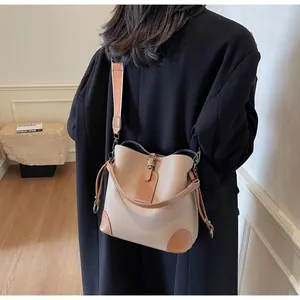 Litchi pattern leather bucket bag with contrast trim and wide woven shoulder strap