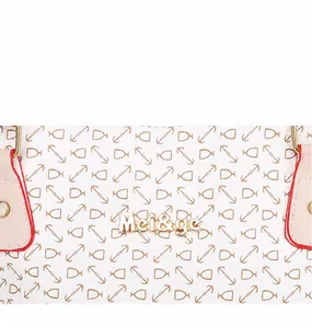 Detalle de bolso de cuero blanco con estampado de anclas y logo de marca en metal dorado