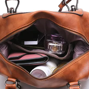 Brown vintage Boston bag with spacious inner compartments and textured faux leather finish