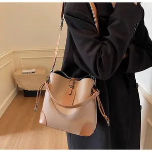 Detail of a two-tone bucket bag featuring lychee grain leather and drawstring accents