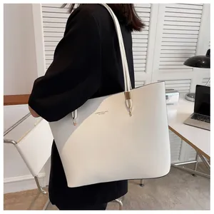 Detail of white tote bag with gold lettering and polished metal hardware on shoulder strap