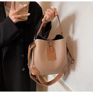 Detailed view of khaki bucket bag featuring lychee texture leather and adjustable strap