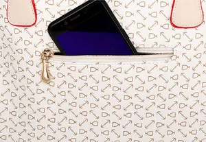 Detalle del bolsillo trasero con cremallera del bolso blanco con espacio para móvil