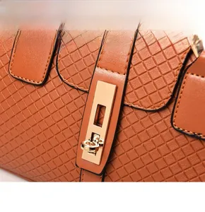 Macro detail of brown quilted leather texture and golden metal lock on the handbag