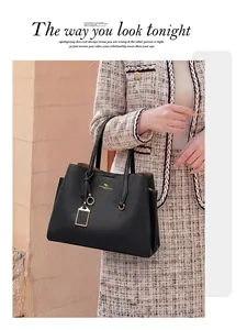 Détail du sac cabas en cuir grainé noir avec ferrures dorées et logo de la marque