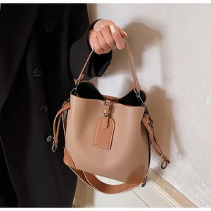 Detail of khaki bucket bag in litchi grain leather with wide fabric strap