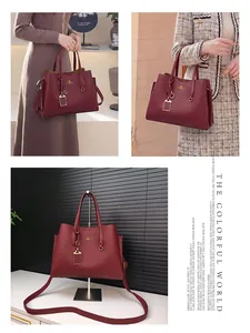 Détail du sac cabas en cuir bordeaux avec logo kangourou doré et bandoulière réglable