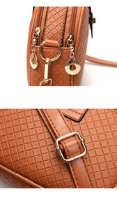 Detail of brown checkered leather bag with dual gold zippers and metallic D-rings