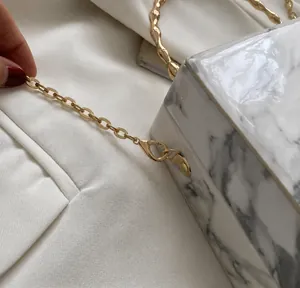 Detailed macro view of the gold-tone hardware hook and marble pattern box bag