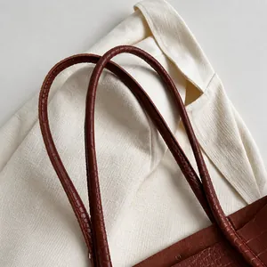 Close-up of comfortable crocodile pattern leather shoulder straps on a brown tote bag