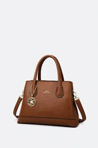 Detail of dark brown pebble leather tote with gold logo and camellia flower charm
