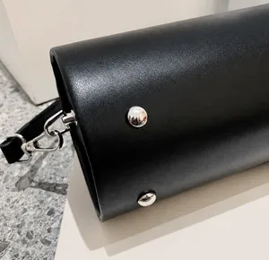 Nahaufnahme der schwarzen Handtasche aus Narbenleder mit schützenden silbernen Bodennieten