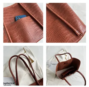 Close-up of brown crocodile embossed tote bag texture with inner pouch and shoulder strap