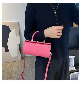 Hot pink cylindrical handbag with silver metal studs and a top handle in detail