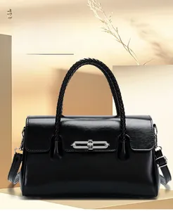 Detail of a black leather handbag with silver interlocking buckle and woven handles