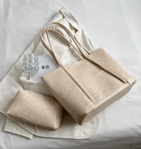 Detail shot of off-white tote bag with faux crocodile pattern and matching pouch set