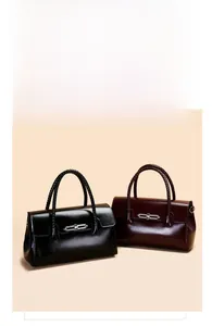 Detail of woven handles and silver metal latches on black and burgundy leather handbags